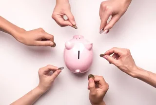 Hands dropping coins into a piggy bank